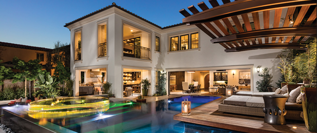 White luxury home with a wide pool, outdoor beds, and pocket doors